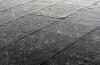 Des gouttes de pluie tombent sur une surface où on voit des carreaux.